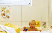 Kind in der Babywanne im Babybad des Sanitärgebäudes
